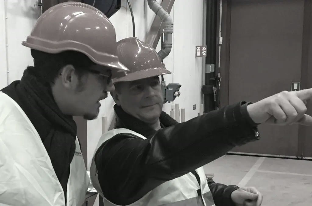 Two technicians in hard hats on site